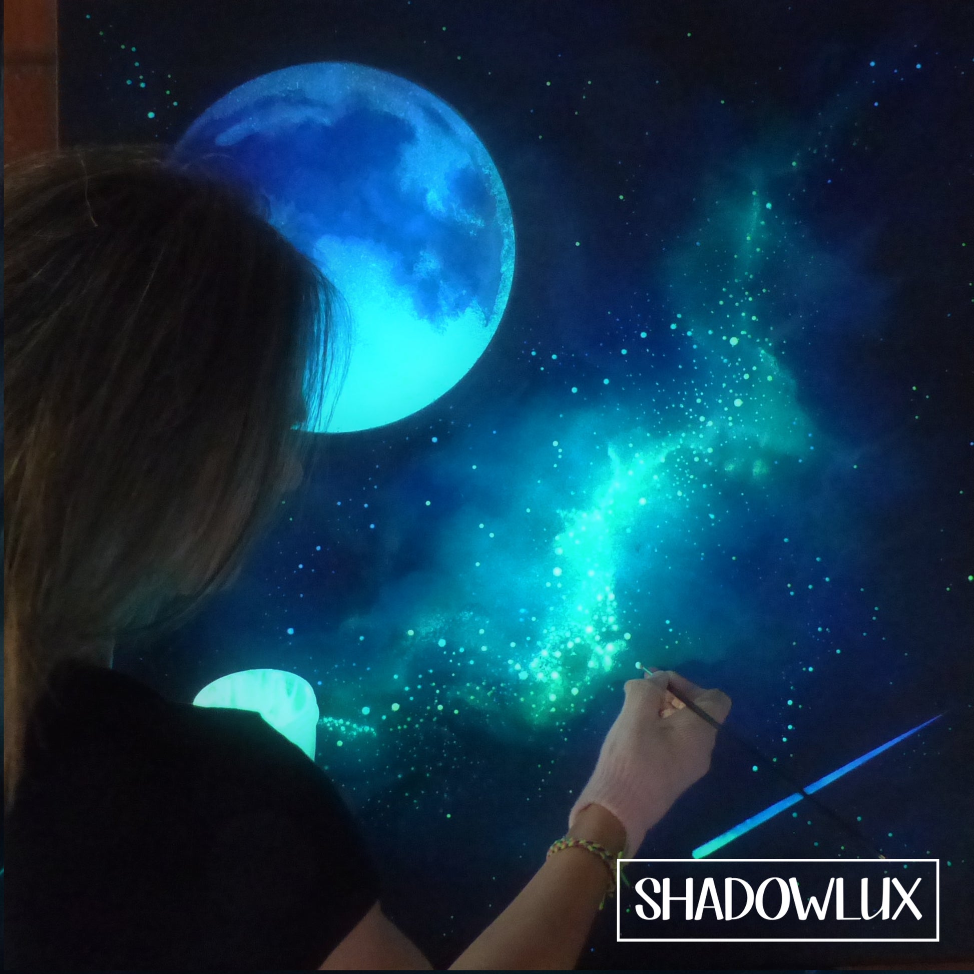 Glow in the dark moon painting with artist Esther Iranyi working on the stars