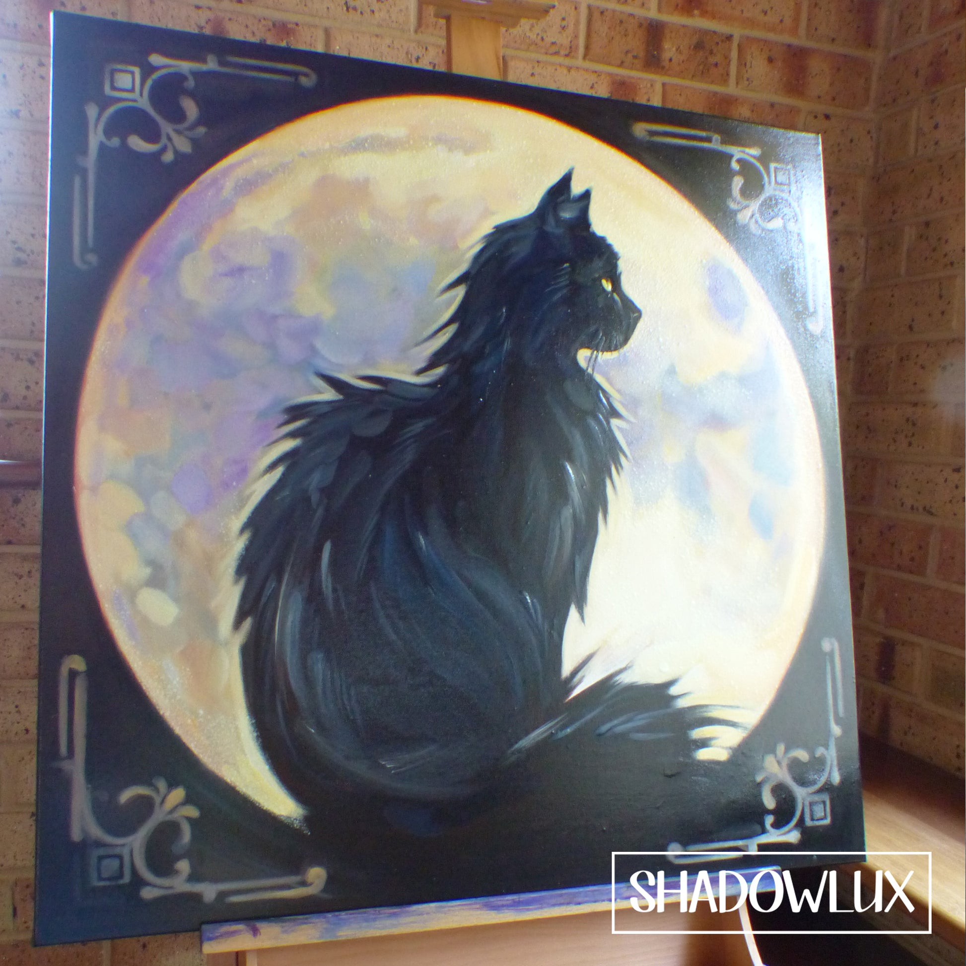 Glow in the dark portrait of a fluffy cat silhouetted against a  full moon, on artists easel
