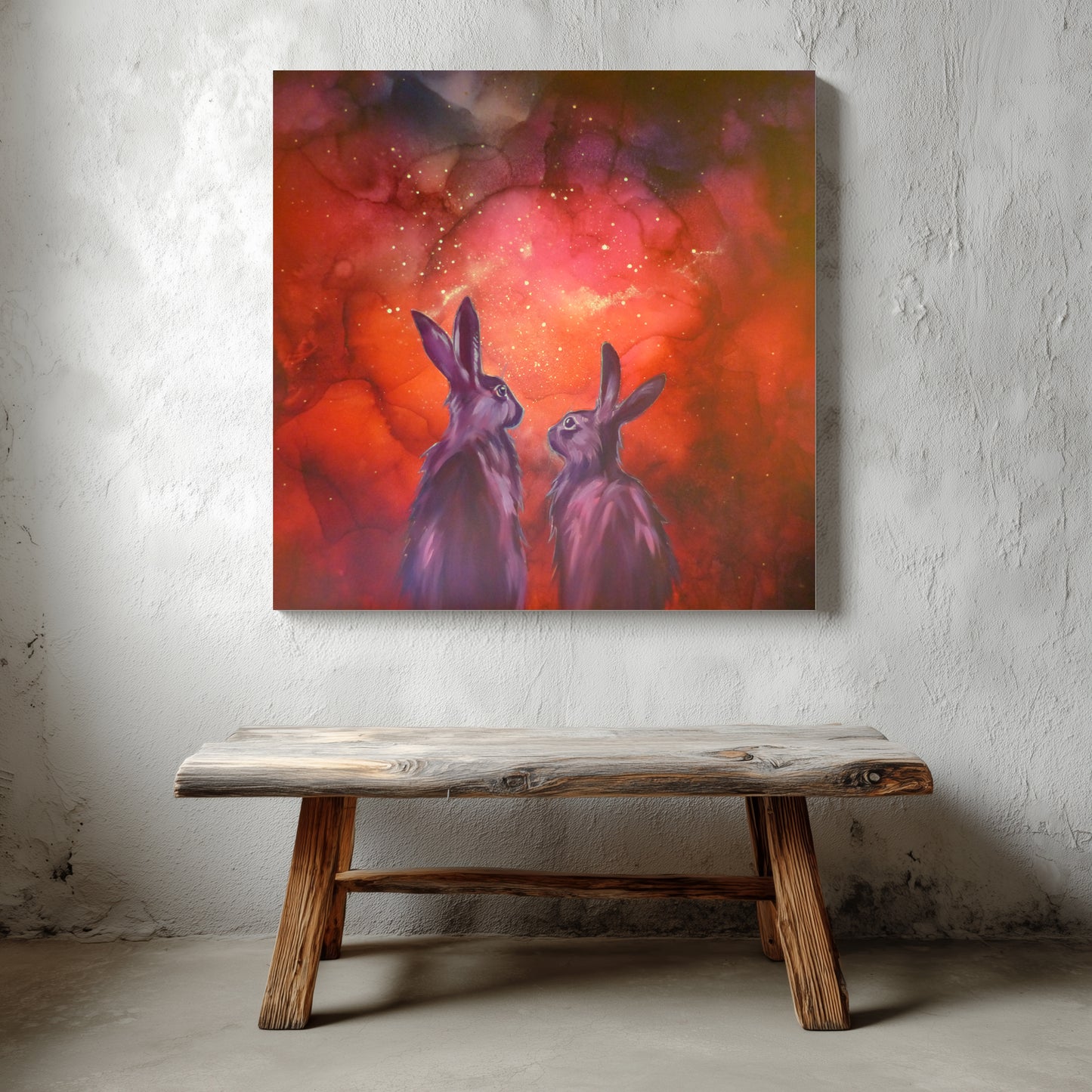 Canvas painting of two rabbits against a red and orange glow in the dark background, displayed on a textured wall above a wooden bench.