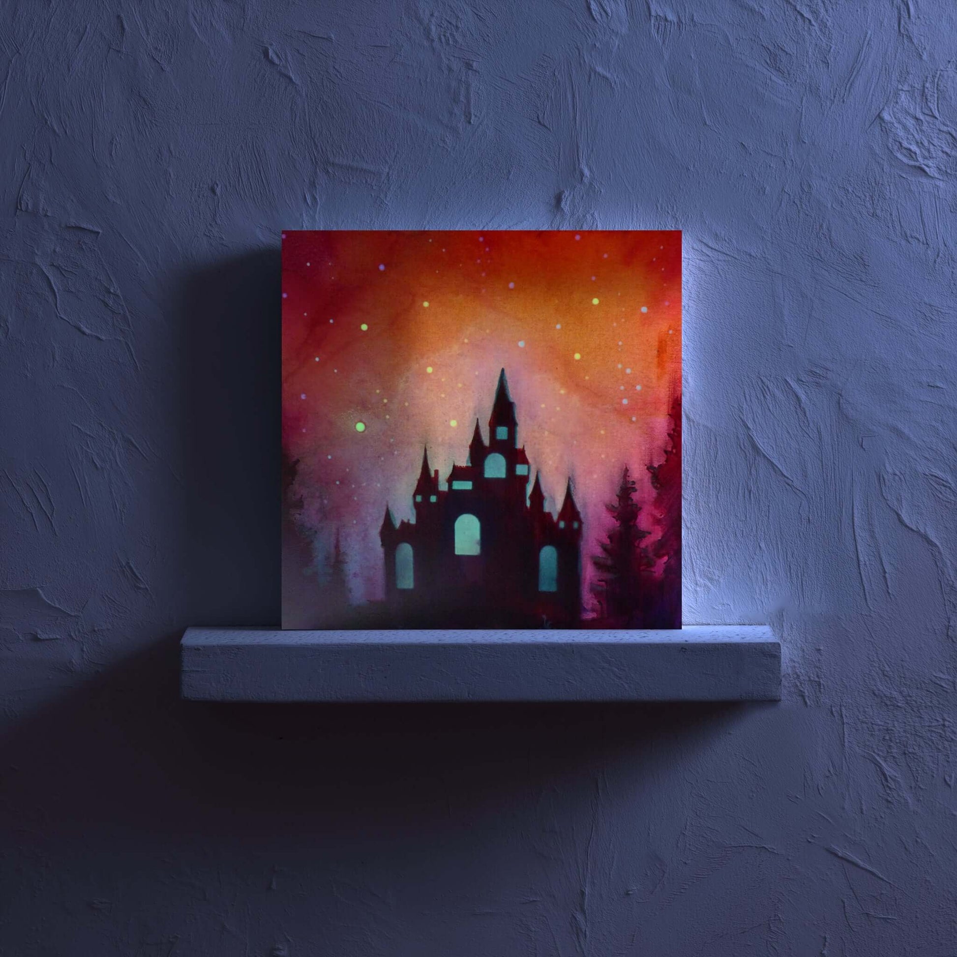 glow in the dark castle silhouette against a colorful sky on a dark wall.