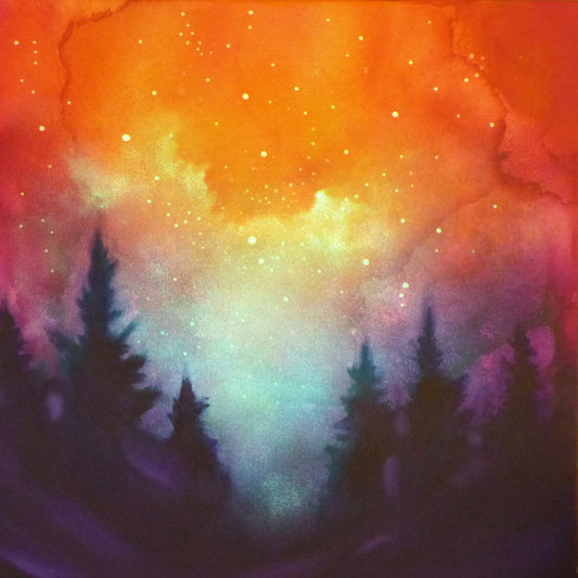 Colorful glow in the dark sky with silhouettes of trees