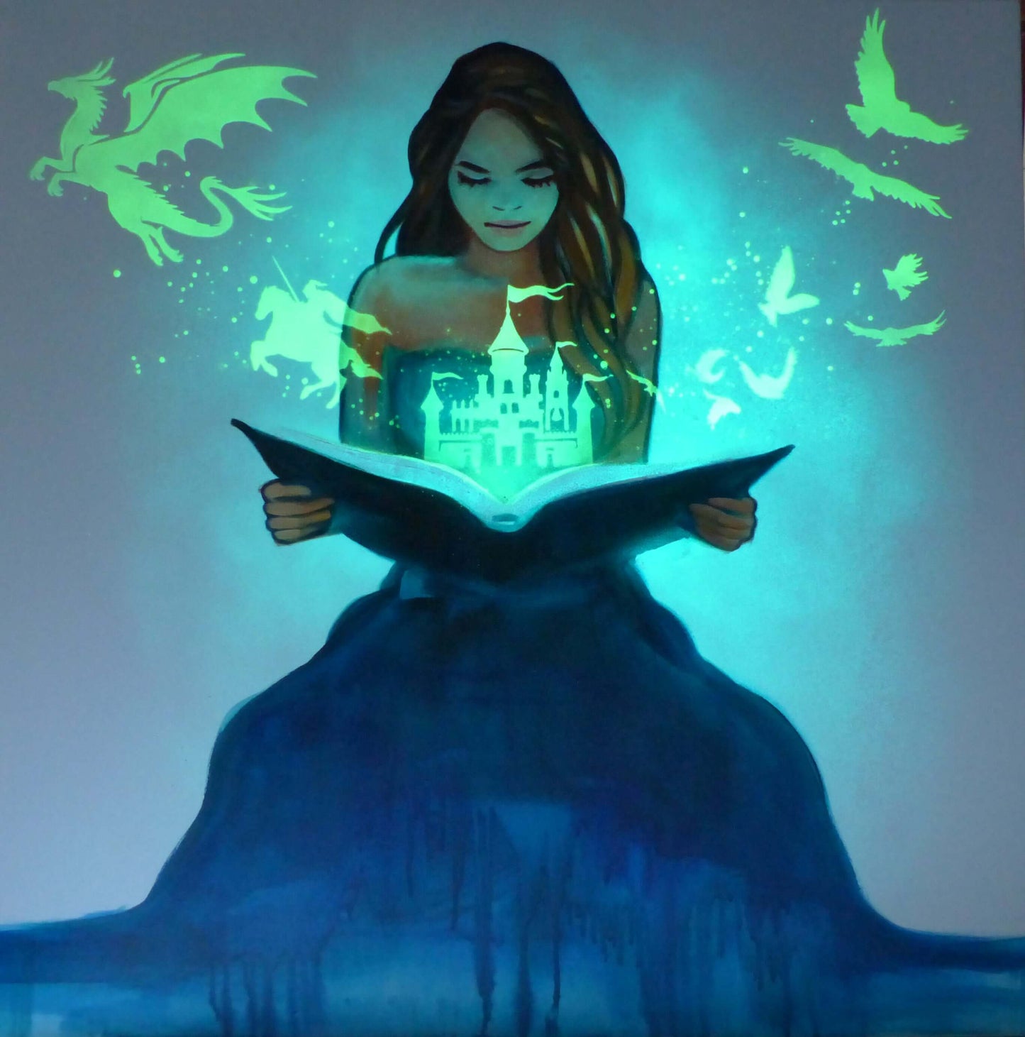 glow in the dark art Woman reading a glowing book with fantasy elements like dragons and fairies.