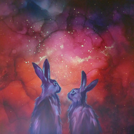 Two glow in the dark  rabbits gazing at a vibrant nebula in space